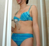 Black haired chick in blue bikini undressing and taking a shower before