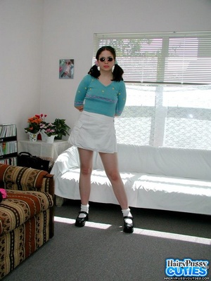 Pigtailed brunette in sunglasses took of white miniskirt and blue top just to expose her hairy snatch by the white couch - XXXonXXX - Pic 2