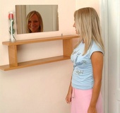 High heeled blonde in white undies slowly undressing by the wall and showing