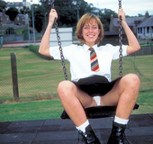 Big boobed redhead in black boots and school girl uniform undressing on