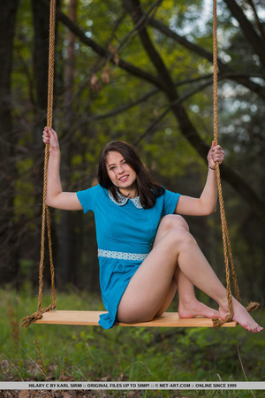 Brunette teen in blue dress swinging out - Picture 1