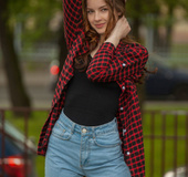 Brunette teen in jeans and red shirt posing outdoors before teasing naked