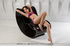 Red lipped brunette taking off lacy lingerie on the black chair before