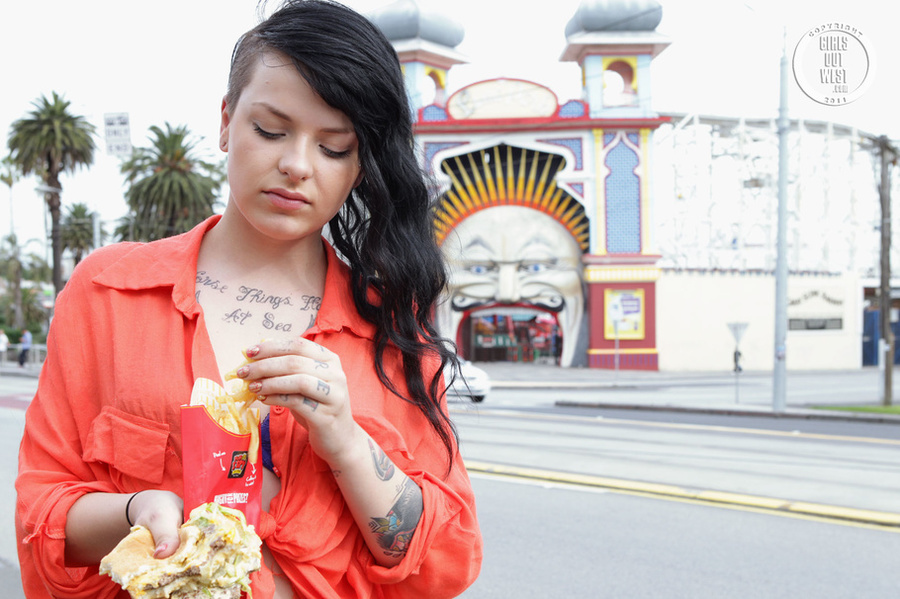 Foxy chick displays her smoking hot body while she eats her burger and fries as she walks around the street wearing her orange shirt, puple bra, white shorts and black high heels. - XXXonXXX - Pic 11
