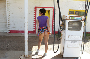 Nasty MILF reveals her lusty tits and hairy crack in different poses in a gas station wearing her violet shirt, multi colored skirt and white rubber shoes. - Picture 12
