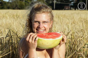 Blonde babe with glasses teases with her foxy body while she eats her watermelon in a crop field before she stips off her white dress and shows her lusty pussy and sweet crack in different poses in a crop field. - XXXonXXX - Pic 1