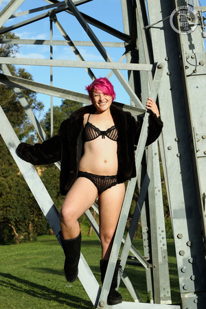 Pink haired chick display her foxy body outdoor wearing her black lingerie, coat and boots then shows her juicy boobs before she pulls down her black panty and reveals her indulging pussy. - Picture 1
