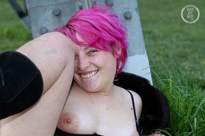 Pink haired chick display her foxy body outdoor wearing her black lingerie, coat and boots then shows her juicy boobs before she pulls down her black panty and reveals her indulging pussy. - Picture 8