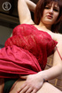 Cute redhead peels off her red dress and reveals her indulging boobs and