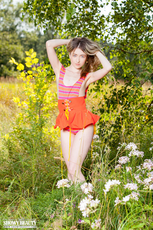 Cute babe teases with her skinny body in pink and orange leotard and orange skirt and before she gets naked and expose her small tits and juicy pussy in different poses in a flower garden. - Picture 2