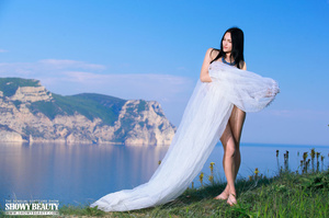 Luscious hottie pose naked and displays her indulging body with alluring boobs and juicy pussy in different poses while holding her white veil in different poses by the sea side. - Picture 1