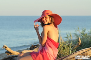 Cute babe wearing pink hat takes off her pink shawl and expose her skinny body with tiny tits and lusty pussy in different poses at the beach. - XXXonXXX - Pic 1