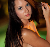 Nighttime shots of a tanned brunette in pink bikini
