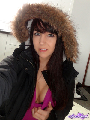 Winter jacked brunette takes off her clothes on the floor - Picture 3
