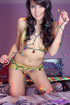 Playful brunette wearins gold two piece outfit wraps christmas lights