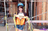 Kinky brunette wearing blue safety hat and construction vest waks arouns