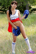 Cute brunette cheerleader with pigtails plays around outdoors wearing