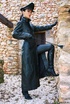 Red lipped brunette in black leather coat and cap exposing her tits under