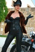 Red lipped mistress in leather outfit and fur teasing outdoors before