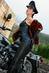 Red lipped mistress in leather outfit and fur teasing outdoors before