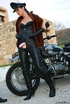 Red lipped mistress in leather outfit and fur teasing outdoors before