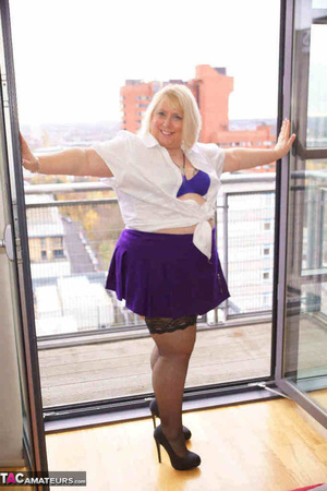 High heeled bbw in black stockings and purple miniskirt sheds blue bra and exposing her pierced snatch on the balcony - Picture 3