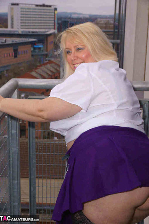 High heeled bbw in black stockings and purple miniskirt sheds blue bra and exposing her pierced snatch on the balcony - Picture 6