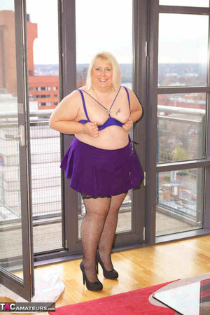 High heeled bbw in black stockings and purple miniskirt sheds blue bra and exposing her pierced snatch on the balcony - Picture 16