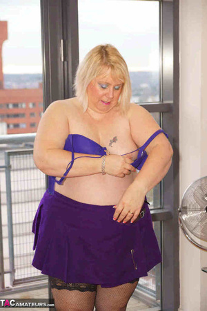 High heeled bbw in black stockings and purple miniskirt sheds blue bra and exposing her pierced snatch on the balcony - Picture 18