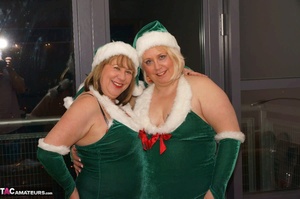 Blonde bbw and her brunette mate posing in green x-mas outfit before enjoying lesbian pussy licking on the couch - Picture 1