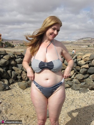 Older babe with red nails and big tits wiggles out of striped swimsuit before posing naked on the shore - XXXonXXX - Pic 18