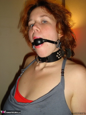 Collared redhead with blue eyes wearing gag ball and handcuffs before posing naked on the blue couch - XXXonXXX - Pic 5