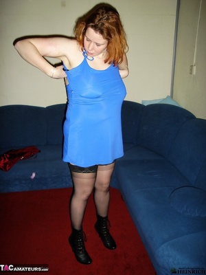Busty redhead in black stockings and blue dress getting nude and posing naked on the red carpet - Picture 1