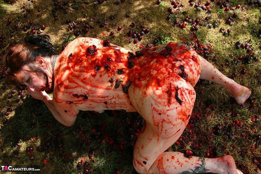 Chubby brunette with big tits gets her tattooed body covered with plums while posing on the ground outdoors - XXXonXXX - Pic 8