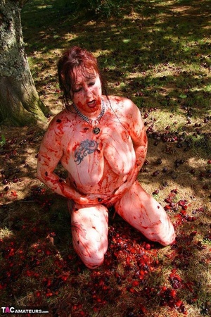 Chubby brunette with big tits gets her tattooed body covered with plums while posing on the ground outdoors - XXXonXXX - Pic 18
