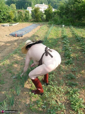 Dark haired wife with huge hooters working in the garden and showing her shaved pussy while posing in rubber boots - XXXonXXX - Pic 8