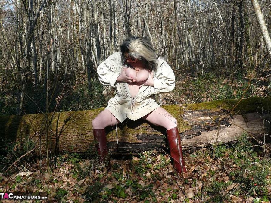 Mature gal in rubber boots sheds her coat before covering her naked body with mud and peeing in the puddle - XXXonXXX - Pic 5