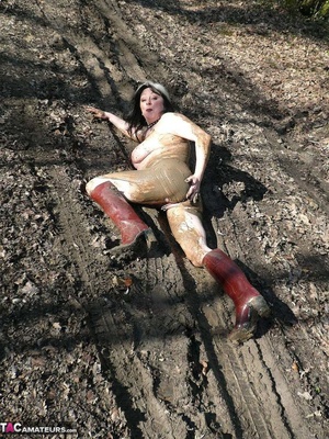 Mature gal in rubber boots sheds her coat before covering her naked body with mud and peeing in the puddle - XXXonXXX - Pic 13
