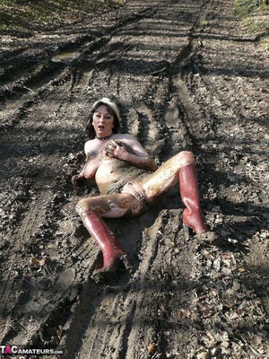 Mature gal in rubber boots sheds her coat before covering her naked body with mud and peeing in the puddle - XXXonXXX - Pic 15