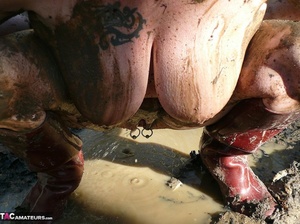 Mature gal in rubber boots sheds her coat before covering her naked body with mud and peeing in the puddle - Picture 19