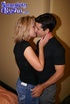 Kinky short haired blonde wearing black top and denim skirt kisses masculine