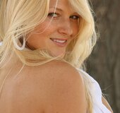 Grey eyed blonde in sexy white bikini teasingly posing by the tree outdoors