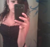 Tatted-up brunette in a corset gets naked on cam