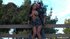 Leaning against a wooden fence, he grips her waist, hiking her skirt for