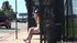 Petite, in yellow, with flip flops and shades, she waits on the bus bench