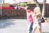Strutting around in a very short jean skirt, she smiles holding hands