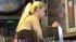 Long blonde hair cascades down her back, as she sits at a bar, looking